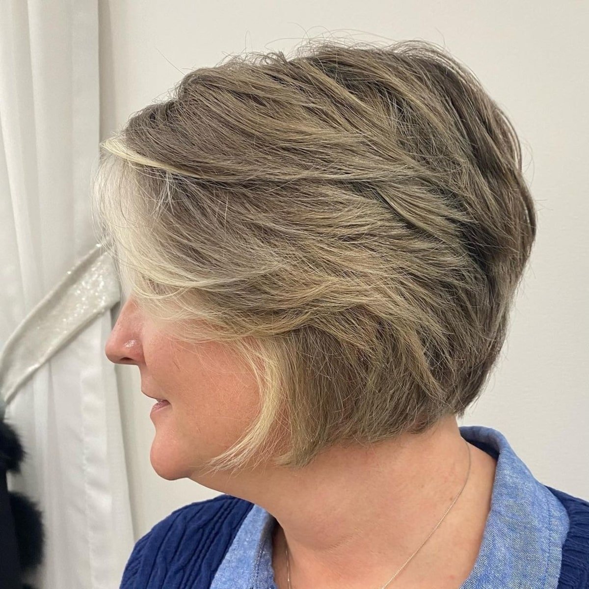 feathered pixie bob with side-swept bangs for women over 60 with fine hair