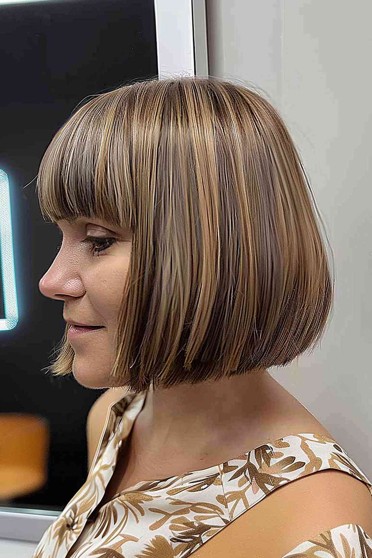 Chin-length modern straight bob with bangs featuring balayage highlights