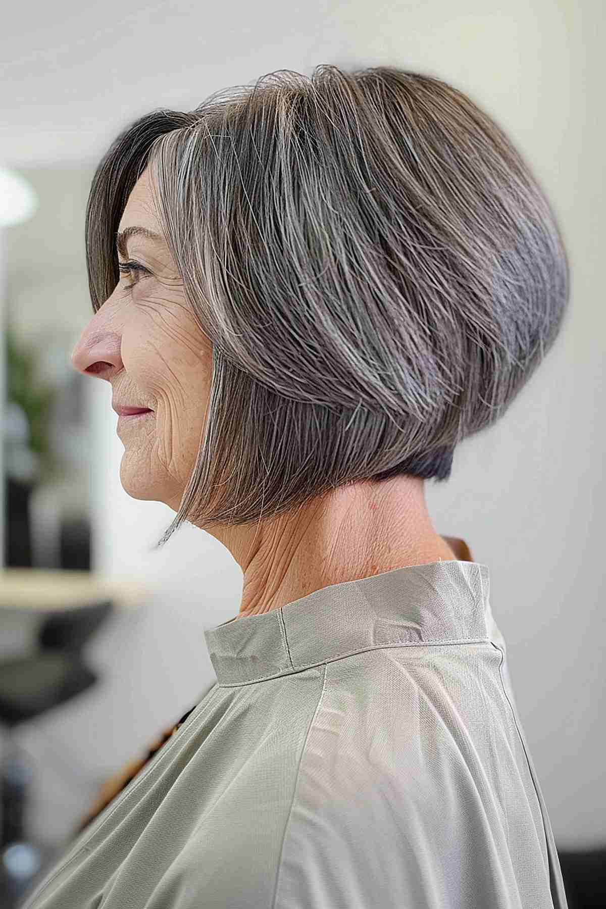 A woman over 60 with salt and pepper hair and a wedge cut