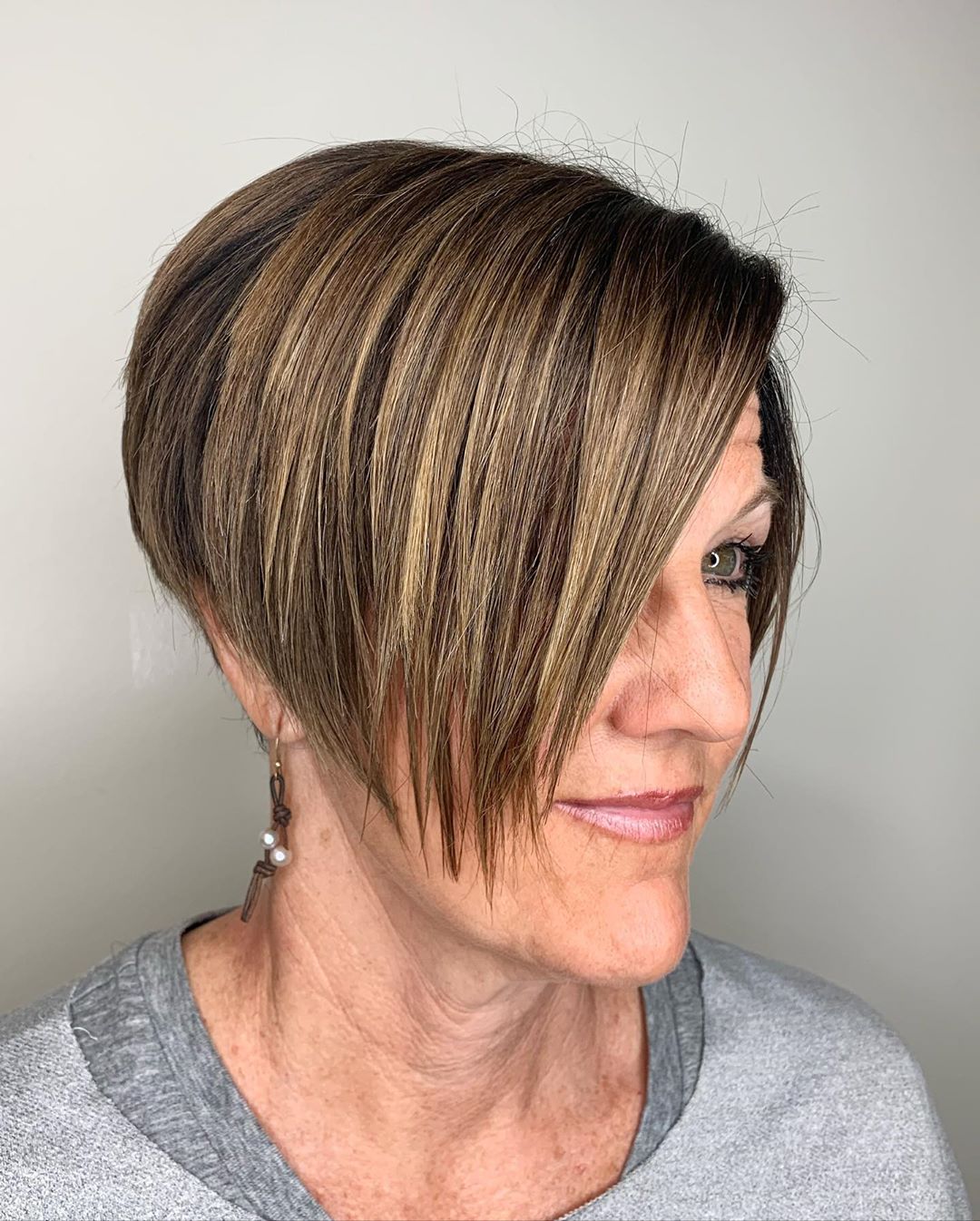 pixie haircut with side-swept bangs for women aged 50 to look younger