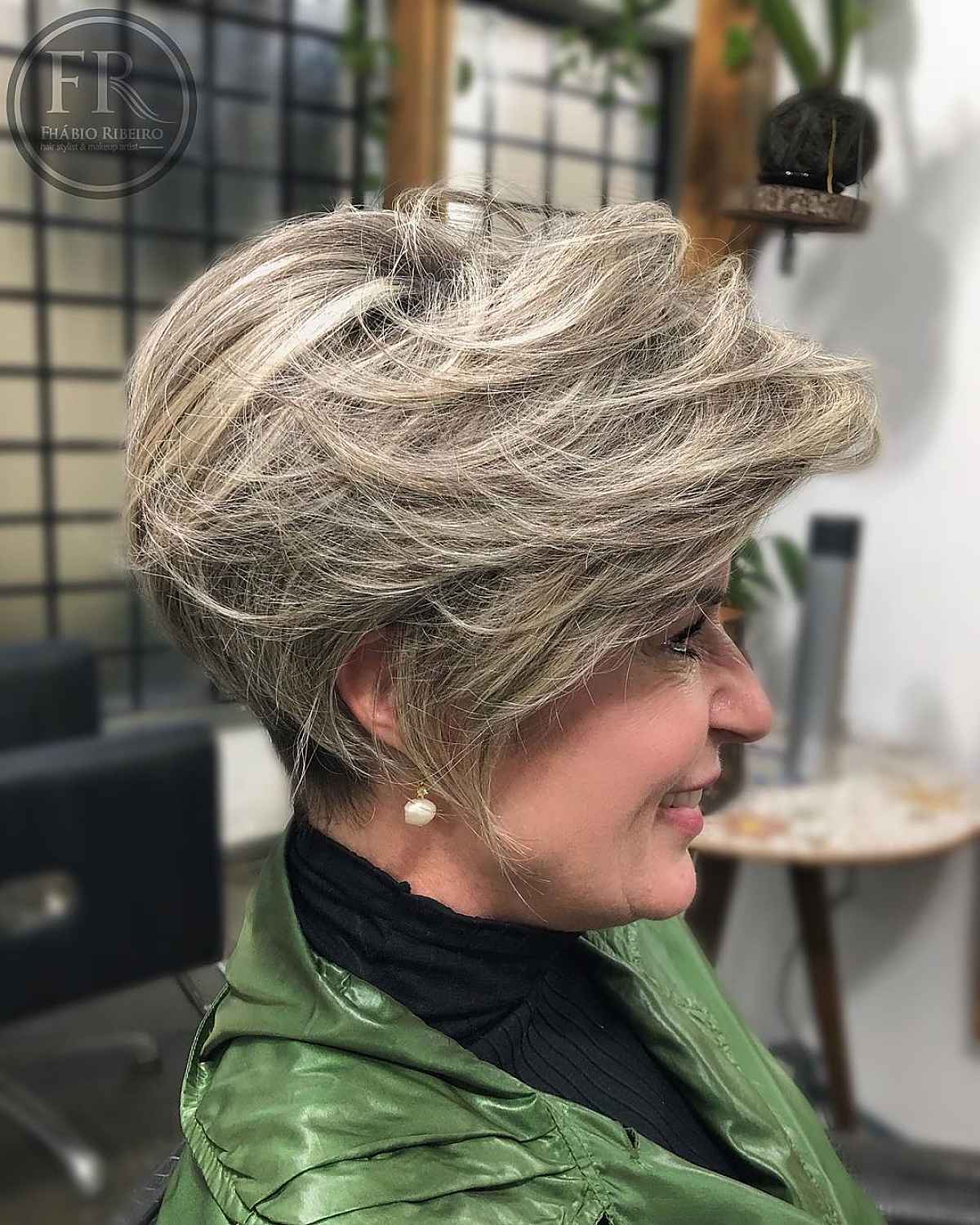 Layered short bob with feathered side-swept bangs for older women.